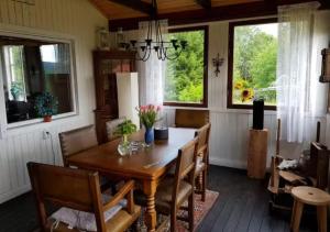 une salle à manger avec une table, des chaises et des fenêtres dans l'établissement Cozy cottage near Hassela ski resort and nature!, 