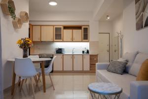 a kitchen and living room with a couch and a table at Pnoé Luminous Apartment in Nafplio