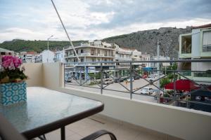 a balcony with a table and a view of a city at Pnoé Luminous Apartment in Nafplio