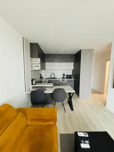 Una cocina y una sala de estar con mesa y sillas. en Moruse airport apartment, en Prievoz