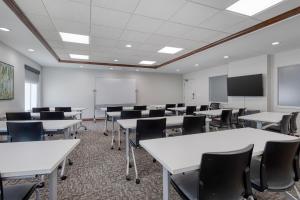 an empty classroom with tables and chairs and a screen at Best Western Byron Center in Byron Center +27 photos