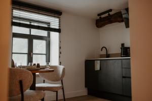 a kitchen with a table and chairs and a window at Molhemhoeve in Peer