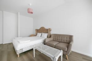 a bed and a couch in a room at Maison Douceur Appart 2 chambres jardin parking Wifi proche centre Evreux in Évreux