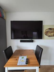 a wooden table with chairs and a television on a wall at Deers view in South Marston