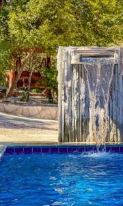 a water fountain in the middle of a swimming pool at chacara joao de barro in Pirenópolis +9 photos