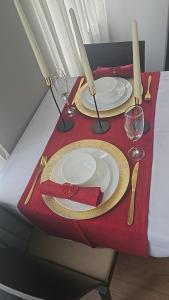 a red table with two plates and wine glasses on it at Appartement diamant in Brussels