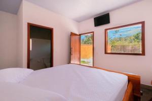 a bedroom with two white beds and a window at chacara joao de barro in Pirenópolis
