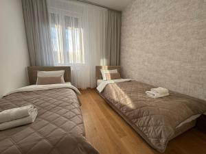 a bedroom with two beds and a window at Premier Nova Residence in Novi Sad