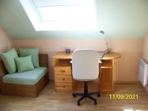 a room with a desk and a chair and a desk with a lamp at La Salamandre in Écouflant