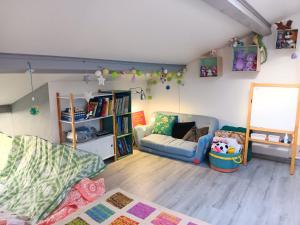 a living room with a couch and a book shelf at La maison multicolore in Livron-sur-Drôme +28 photos