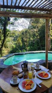 a table with plates of food next to a swimming pool at Alma Glamping in Xalapa