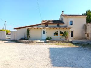 a white house with a driveway in front of it at La maison multicolore in Livron-sur-Drôme