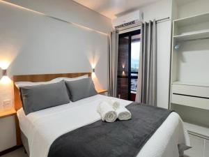 ベレンにあるComfortable 2BR Apt in Belém Best Areaのベッドとタオル2枚のある寝室