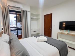 ベレンにあるComfortable 2BR Apt in Belém Best Areaの白いベッドとテレビのある寝室