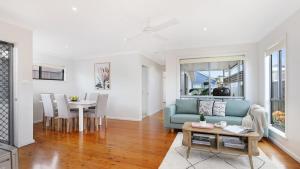 a living room with a blue couch and a table at Rockpool Retreat in Currarong