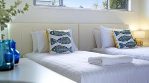two white beds with pillows on top of them at Rockpool Retreat in Currarong