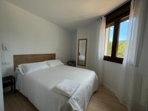 una camera da letto bianca con un letto e una finestra di Tres Olivos a La Alberca