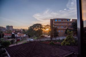 a view of a rooftop of a building with the sunset at The House in Kampala