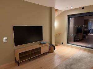a living room with a flat screen tv on a wall at Aurora Panorama in Tromsø