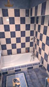 a bathroom with a bath tub with a black and white tiles at Gîte le Lynx in Passenans