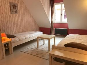a small bedroom with two beds and a table at Gîte le Lynx in Passenans