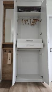 a white closet with wooden floors and white shelves at let health flow in Montevideo