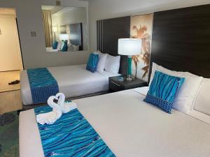 a hotel room with two beds with swans on them at Palms At Waikiki in Honolulu