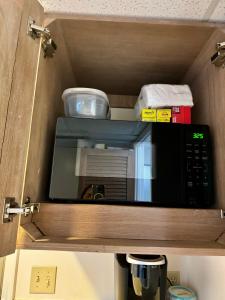 a microwave in a wooden cabinet with some food at Palms at Waikiki in Honolulu