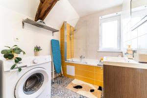 a bathroom with a washing machine and a sink at Le Nid - Hypercentre - 3 beds - Wifi - Netflix in Cambrai +3 photos