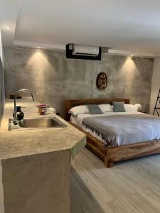 a kitchen with a sink next to a bed at Villa Noelia by Embera Collection in Saboga