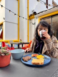 a woman sitting at a table with a plate of food at Vecinos by La Palmera in Bogotá