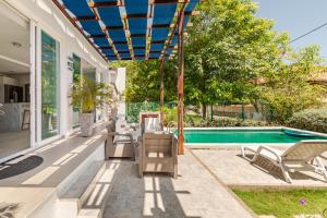 Un patio con mesa y sillas junto a una piscina. en Vacation Home Escape & Villa with pool, en El Morro