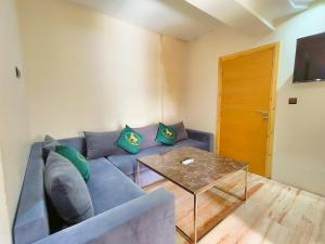 a living room with a blue couch and a table at Apartment chakira family only in Tangier