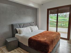 a bedroom with a large bed with a large window at Apartment chakira family only in Tangier