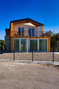 a yellow house with a balcony on top of it at Margherita Luxury Resort near Venice in Santo Stino di Livenza