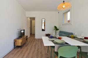 a living room with a table and chairs and a television at Margherita Luxury Resort near Venice in Santo Stino di Livenza