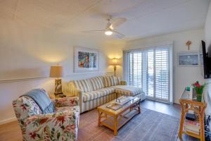 een woonkamer met een bank en een tafel bij Resort Condo Steps to Beach Snowbirds Welcome! in Saint Augustine Beach