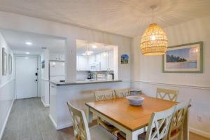 een keuken en eetkamer met een houten tafel en stoelen bij Resort Condo Steps to Beach Snowbirds Welcome! in Saint Augustine Beach