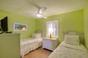 een slaapkamer met twee bedden en een plafondventilator bij Resort Condo Steps to Beach Snowbirds Welcome! in Saint Augustine Beach +21 foto's