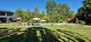 a house with a yard with a swimming pool at Cabaña Serrano in Linares +5 photos