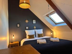 a bedroom with a bed with two towels on it at Les libellules in Lanvallay +102 photos