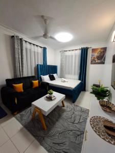 een woonkamer met een bank en een tafel bij Zamara homes 