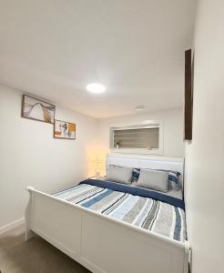 a white bedroom with a bed in a room at Cozy 2 Bedroom Suite Close to Amenities in Edmonton