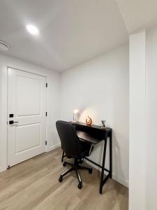 a desk and a chair in a room with a door at Cozy 2 Bedroom Suite Close to Amenities in Edmonton