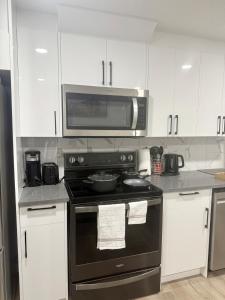 a kitchen with a black stove and a microwave at Cozy 2 Bedroom Suite Close to Amenities in Edmonton