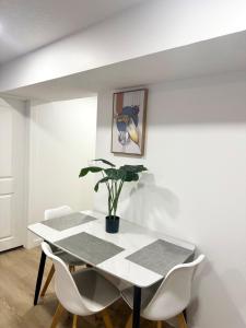 a dining room with a white table and white chairs at Cozy 2 Bedroom Suite Close to Amenities in Edmonton