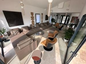 einen Blick über ein Wohnzimmer mit Sofa und Stühlen in der Unterkunft Sunny Year-Round Provençal Luxury Retreat in Saint-Saturnin-dʼApt