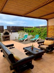 ラ・オリーバにあるBlue Wave House Corralejoのパティオ(椅子、ソファ、テーブル付)