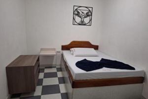 a small bedroom with a bed and a desk at Hotel Playa Itagui in Itagüí