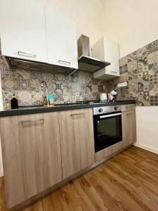 a kitchen with white cabinets and a black oven at Appartamento Revoltella16 in Trieste